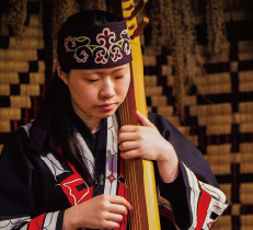 アイヌの伝統的な楽器を弾くアイヌの女性イメージ